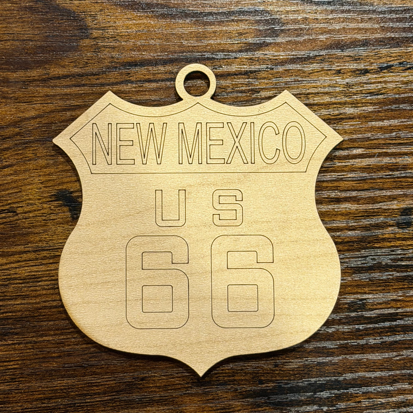 Wooden ornament with 'New Mexico U.S. 66' text on a wooden surface