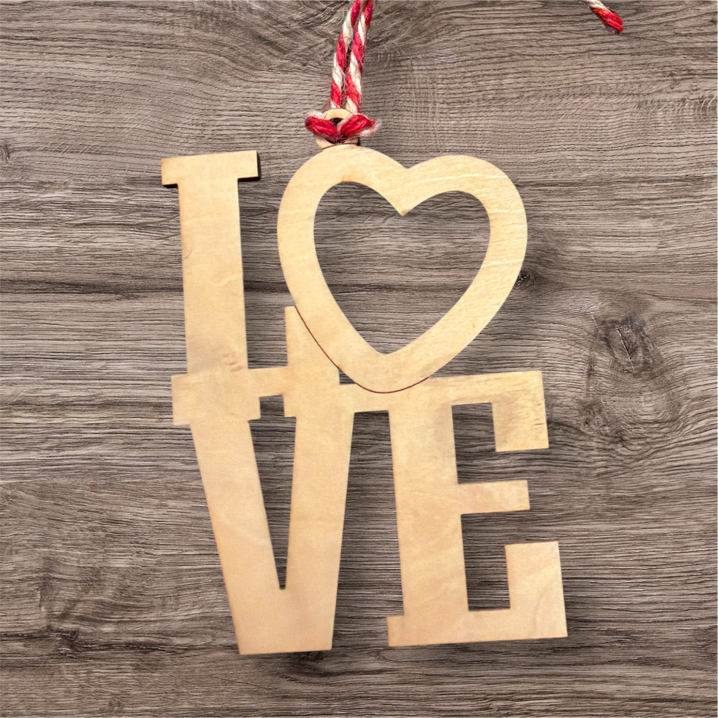 Wooden ornament spelling 'LOVE' with a heart on a wooden surface