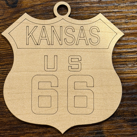Wooden cutout of a shield shape with '66' and 'Kansas' text on a wooden background